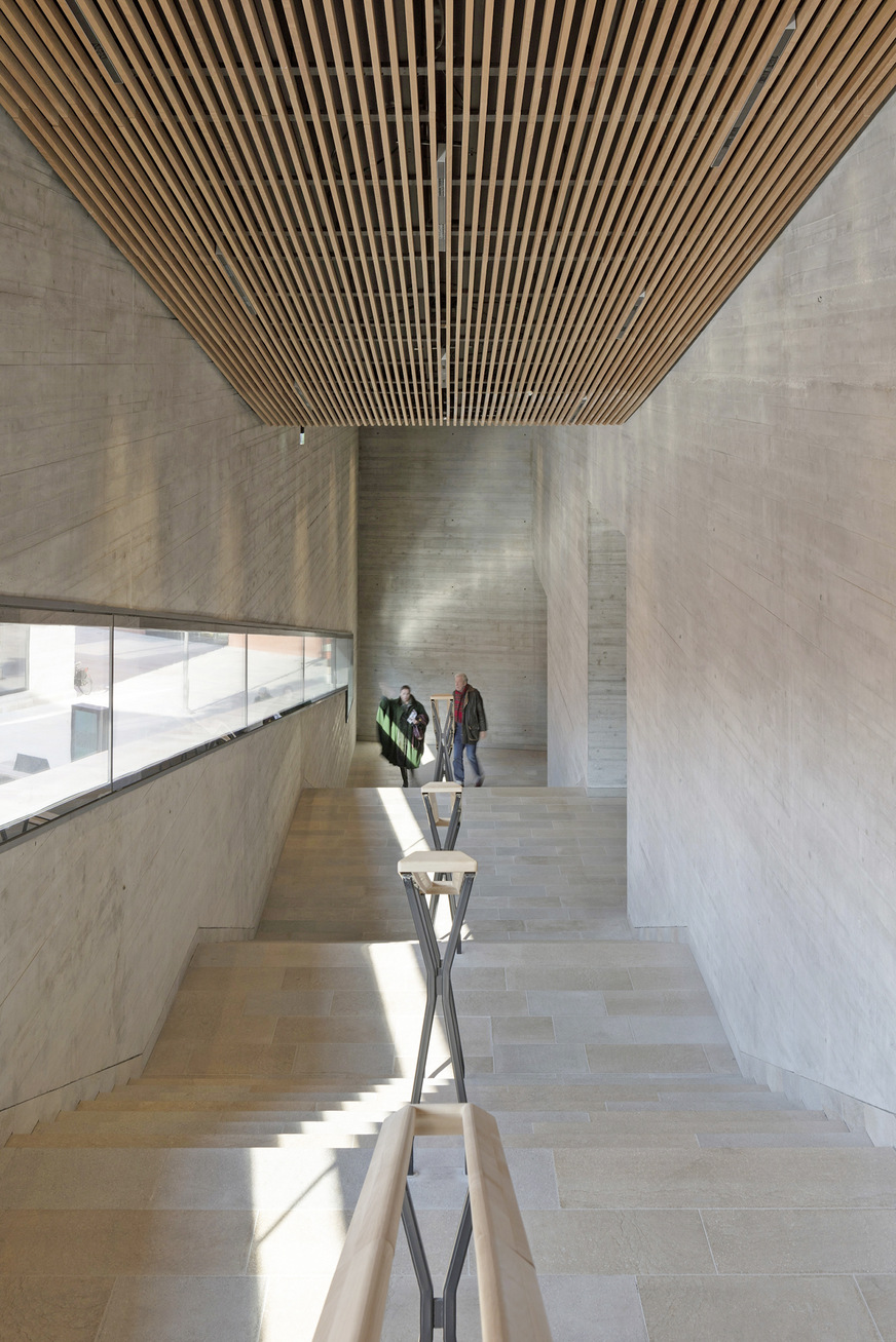 Die Schlitzdurchlässe wurden in die fein strukturierte Holzlamellendecke integriert.