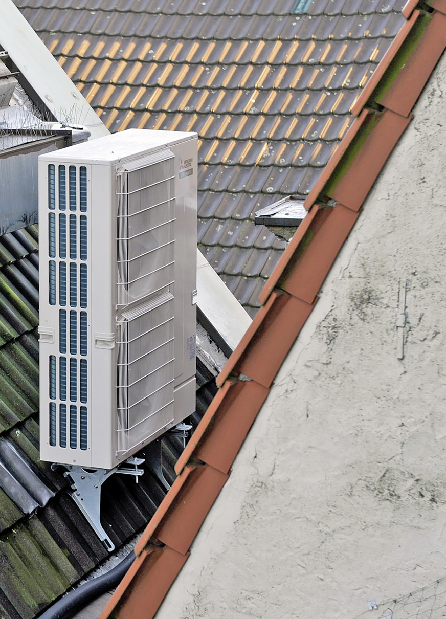 Das Außengerät ist auf einer kleinen Konsole oberhalb der Dachtraufe aufgestellt