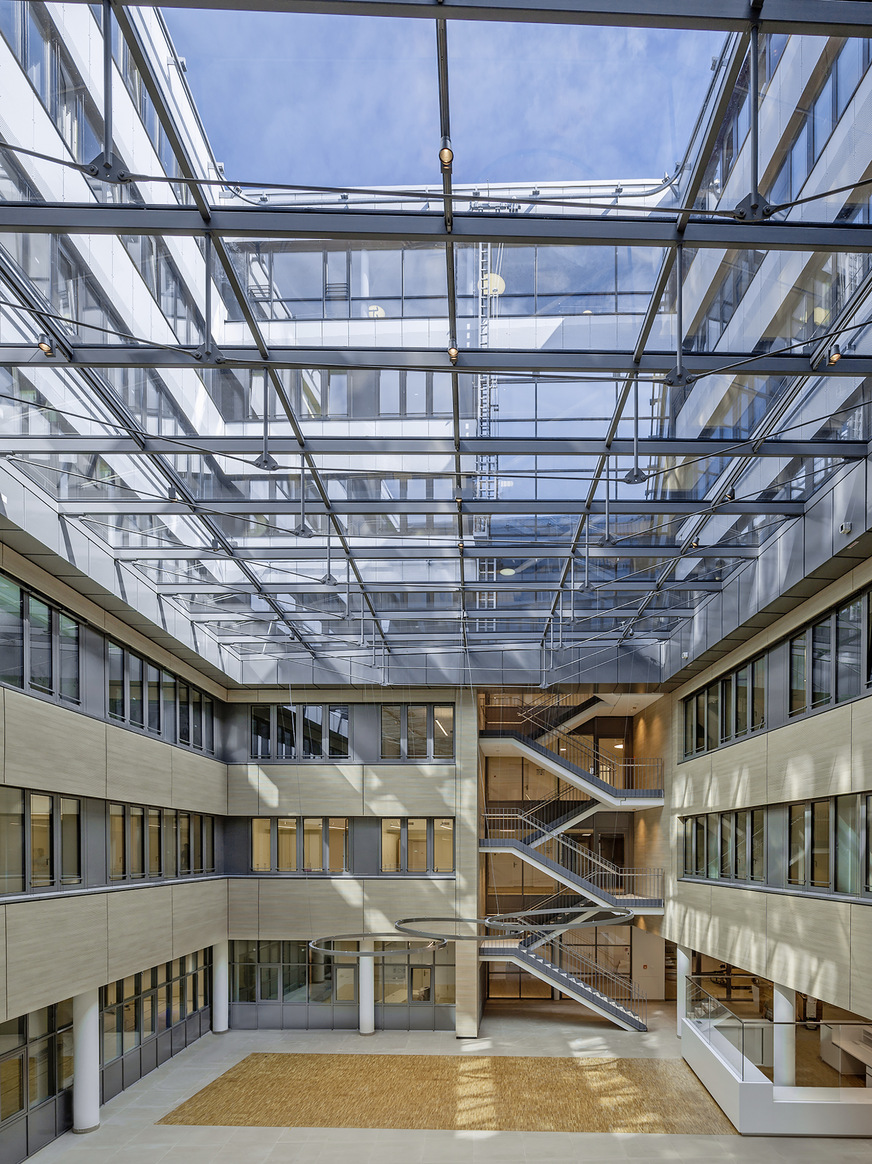 Das Gebäude gruppiert sich um zwei Lichthöfe, von denen einer als Eingangs-Atrium überdacht ist.