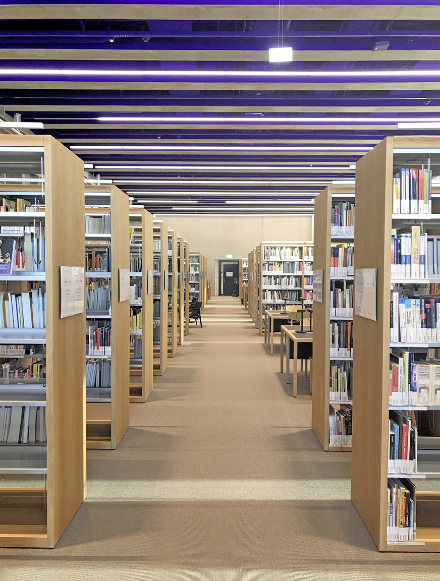 Auch in der Bibliothek liegen alle Zuluft-Leitungen sichtbar in den Rippen der Betonrippendecken. Entsteht Überdruck, entweicht die Luft über die Überströmelemente in das angrenzende Atrium.