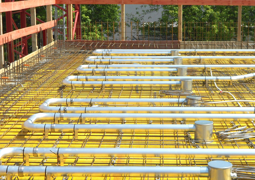 In die Betondecken werden rasterbezogen Kühlrohre aus wärmeleitendem Aluminium eingegossen.