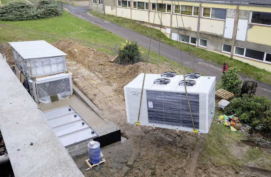 Der Kaltwasser-Erzeuger wurde per Kran an den Aufstellort zwischen zwei Gebäuden gehoben.