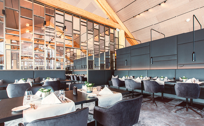 Im Restaurant „Esszimmer“ sind die Schlitzauslässe Indul von Kiefer Klimatechnik auf verschiedenen Höhenniveaus als horizontale Linienelemente innerhalb der Satteldachflächen angebracht.