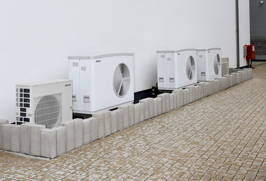 Die drei Luft-Wasser-Wärmepumpen WPL 25 AC heizen und kühlen den Gewerbebau des Ensembles. Im Vordergrund zu sehen: das Multisplit-Außengerät CUR 6-122 der zusätzlichen Klimatisierung für das Ladenlokal im Erdgeschoss.