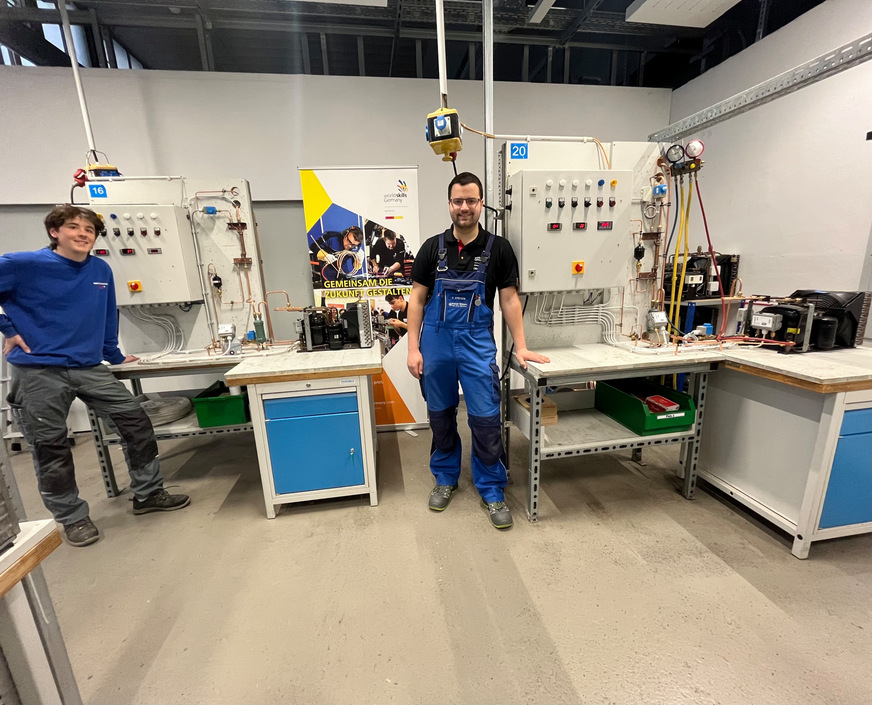 Hannes Eckert (links) und Frederik Stiegen (rechts) präsentieren ihr Ergebnis vom Vergleichswettkampf (Kälteanlage mit Heißgas-Abtauung)