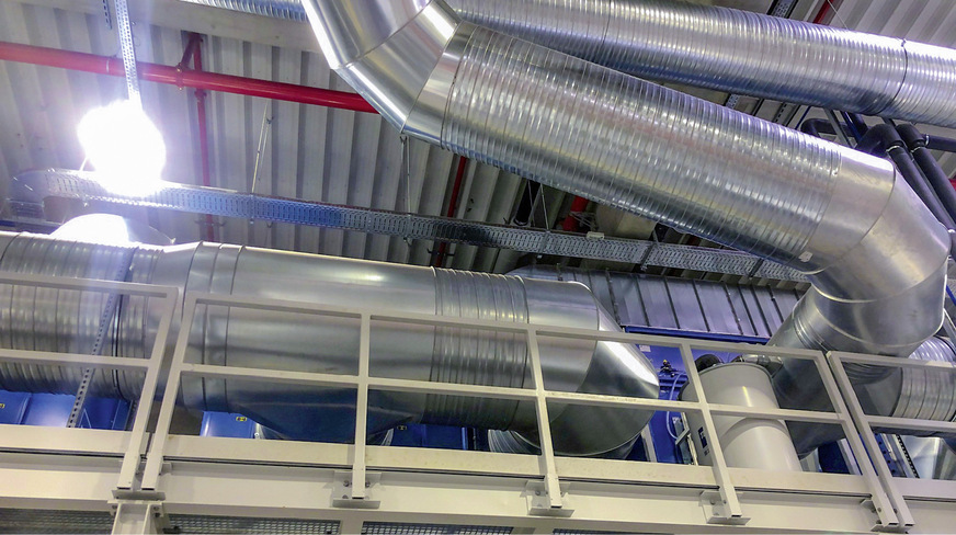 Großformatige Absaugrohre unter dem Hallendach leiten die abgesaugten Schweißdämpfe zu einem Wärmeübertrager auf dem Hallendach.