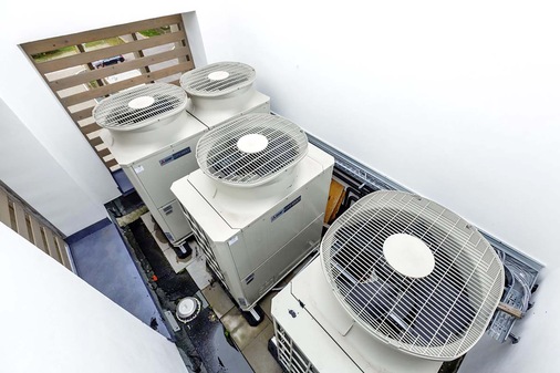 Drei HVRF-Außengeräte aus der City Multi Serie mit unterschiedlichen Leistungen befinden sich auf einem eingehausten Seitendach. - © Bild: Mitsubishi-Electric
