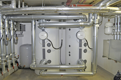 Zwei 1000-l-Pufferspeicher halten das bis zu 60 °C warme Heizungswasser vor, welches für die Heizkreisläufe, die Lüftungsanlage und eine Trinkwarmwasserstation genutzt wird. - © Bild: Stiebel Eltron
