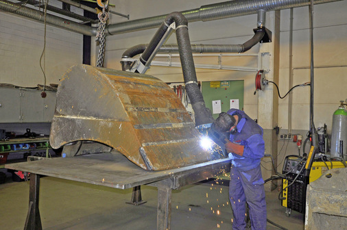 Für die Reparatur großer Anbaugeräte wie dieser Baggerschaufel kann der Absaugarm nah an die zu schweißende Stelle herangeführt und flexibel bewegt werden.
