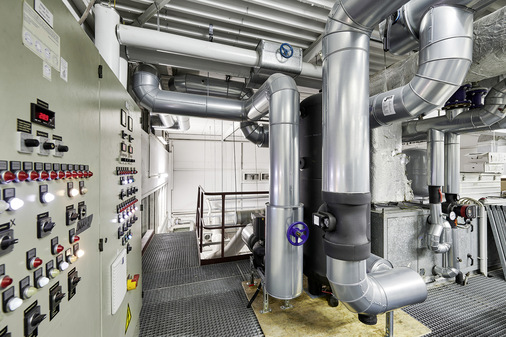 Weil der Raum in den Gebäuden begrenzt ist, wurden lediglich die Pufferspeicher und die Schalt- und Regeltechnik auf einer Empore platziert, die übrige Lüftungs- und Kältetechnik aber komplett auf das Dach ausgesiedelt.