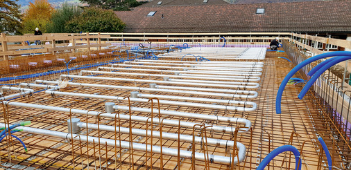  Bevor die Zuluft den Räumen zugeführt wird, durchströmt sie die Kühlrohre innerhalb der Betondecken. Dabei erwärmt sich die kalte Außenluft auf annähernd Deckentemperatur. Mit rund 21 °C erreicht die Zuluft über Deckendralldurchlässe dann die Schulräume.