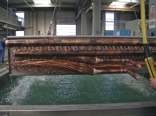 Ein Lamellenwärmetauscher nach der Druckprobe: Ein Nachteil der klassischen 
Bauweise ist der hohe Anteil von Handarbeit, der sich nicht automatisieren 
lässt
