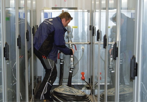 Ein CoolEnergy-Techniker während der Montagearbeiten in dem mit 
Klimaschränken dicht bestückten Serverraum
