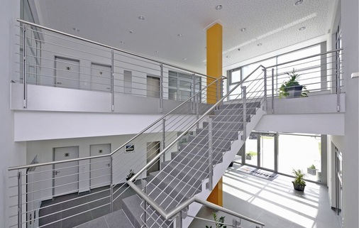 Verbunden sind die beiden Büroflügel mittig durch einen zur Vorder- und 
Rückseite vollflächig verglasten Erschließungstrakt mit einem hellen Foyer 
und einem Treppenhaus.
 - © Freyler
