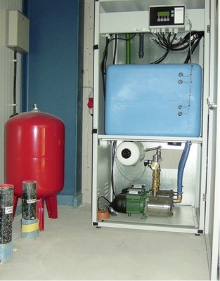 Komplettsystem Druckerhöhungsanlage Tano XL mit integrierter 
Trinkwassernachspeisung, Vor­lagebehälter 200 l (blau), 
Druckausgleichsbehälter 100 l (rot) und Zubringer­pumpe mit Zubehör im 
unterirdischen Beton­fertigteilspeicher
