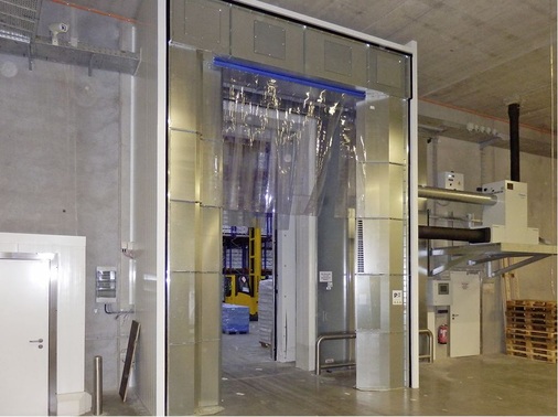 Hier wird der Luftschleier in der 5,2 m hohen Türöffnung zusätzlich durch 
einen Plastikstreifenvorhang ergänzt, um die Effektivität des Gesamtsystems 
weiter zu steigern.
