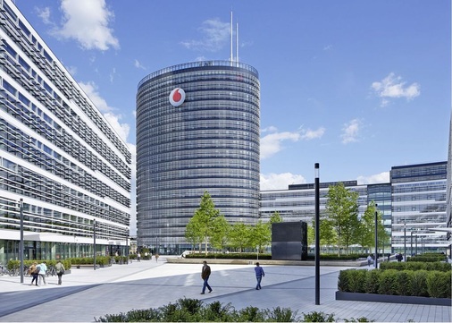 Die Vodafone-Deutschlandzentrale besteht aus einem ellipsenförmigen, 
19-geschossigen Hauptgebäude und drei horizontal ausgerichteten Bauteilen, 
die ähnlich einem Campus um einen gemeinsamen ­dreieckigenInnenhof 
gruppiert sind.
 - © Vodafone GmbH
