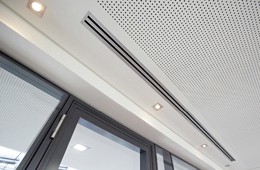 Zur Einbringung der Zuluft in den separaten Besprechungsräumen werden 
lineare Schlitzdurchlässe verwendet, die sich architektonisch ansprechend in 
das Kühldeckensystem integrieren sowie hinsichtlich des Volumenstroms und 
der Strahllenkung…