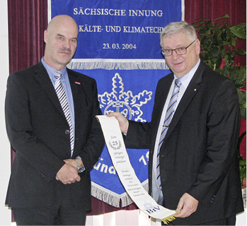 Bild 7: Heribert Baumeister (l.) übergibt den Jubiläumswimpel für die 
Innungsfahne.

