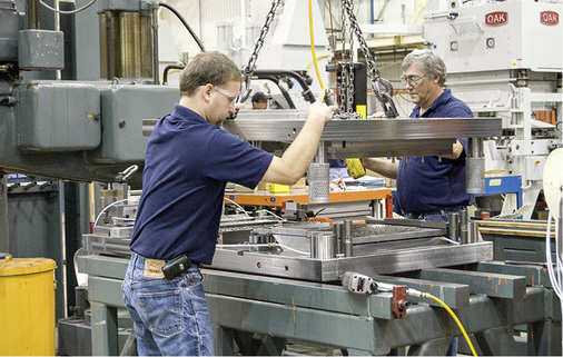 Mitarbeiter bereiten eine Lamellenstanzung vor.


