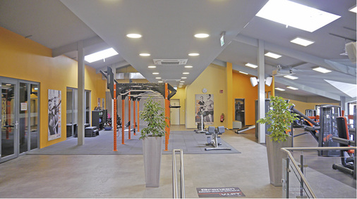 Blick in den Fitness-Club mit den kombinierten Heiz- und Lüftungskassetten 
an der Decke.

