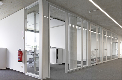 
Mit den atmenden“ Fassadenlüftungsgeräten gelingt auch das Belüften von 
Einzelbüros. Schallisolierende, gläserne Überströmelemente neben den 
Bürotüren ermöglichen hierbei den Luftaustausch mit den anderen Bereichen 
der Etage.

