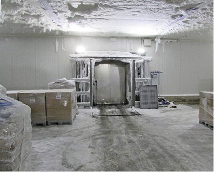 Vereistes Tor und vereiste Geh- und Fahrwege in einem Kühlhaus

