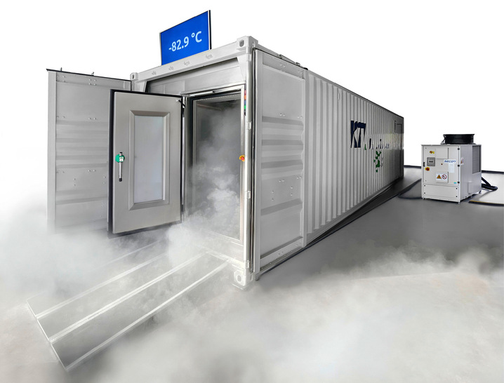 Frontansicht des Ultratieftemperatur-Containers mit Rückkühleinheit an der Seite platziert. Die knapp -83 °C kalte Luft strömt bei geöffneter Tür zum Boden und bildet Nebel. - © Bild: KTI-Plersch
