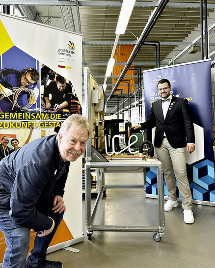 Frederik Stiegen und Karsten Beermann vor der Kälteanlage mit dem Schriftzug „ice“ aus dem Wettbewerb 2022 in ­Nürnberg, die vom IKKE an Frederik Stiegen übergeben wurde, als ­Belohnung für die guten Leistungen.