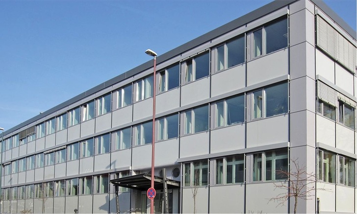 Saniertes Hauptgebäude der HSE Technik GmbH am Dornheimer Weg in Darmstadt. Der niedrigere Energiebedarf des Gebäudes nach der Fassadendämmung war in den Räumen direkt spürbar: Während der Umbauphase, im gesamten kalten Februar des Jahres 2012, als die neue Heizanlage noch nicht montiert, die alte aber schon demontiert war, fiel die Temperatur während der Bürozeit nicht unter 17 °C.