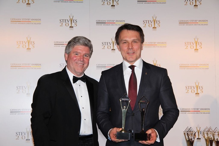 Michael Gallagher (links), Präsident der Stevie Awards gratuliert Peter Fenkl, Vorstandsvorsitzender von Ziehl-Abegg, zu fünf Auszeichnungen bei den Stevie Awards in Berlin.