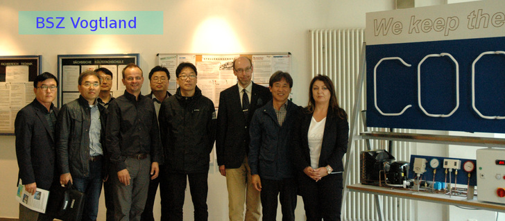 Die Gäste aus Südkorea mit Vertretern des Berufsschulzentrums Vogtland und der Sächs. Kältefachschule vor einer Demonstrations-Kälteanlage im Foyer des Berufsschulzentrums in Reichenbach/Vogtl