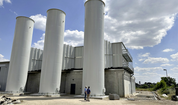 Die Ansicht der Anlage wird geprägt durch die großen Luft/Wasser-Wärmetauscher auf dem Dach des Maschinenhauses und den verbundenen Fortluftkaminen.