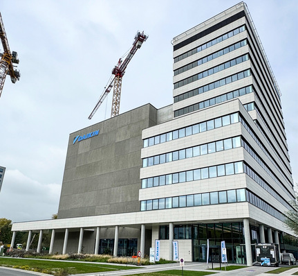 Da, klitzeklein unten rechts, steht das KältenKlub-Mobil neben dem riesigen Gebäude.