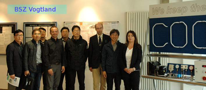 Die Gäste aus Südkorea mit Vertretern des Berufsschulzentrums Vogtland und der Sächs. Kältefachschule vor einer Demonstrations-Kälteanlage im Foyer des Berufsschulzentrums in Reichenbach/Vogtl