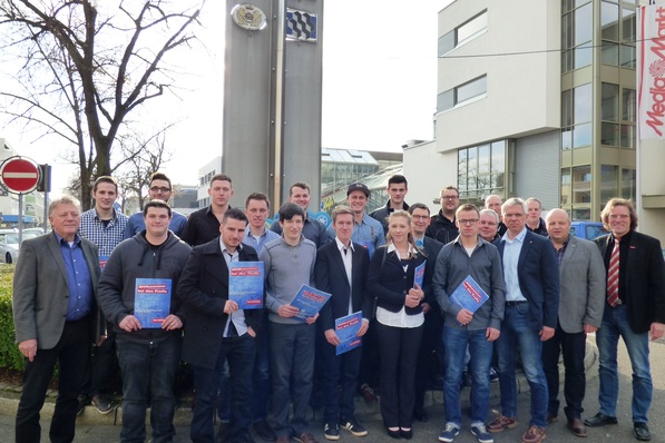 Gruppenbild mit Dame vor der Steele der KHW: 13 frisch gekürte Kältemechatroniker mit ihrem Obermeister Axel Melzer (4.v.r.) und dem Neuwieder KHW-Leiter Fred Kutscher (g.r.)