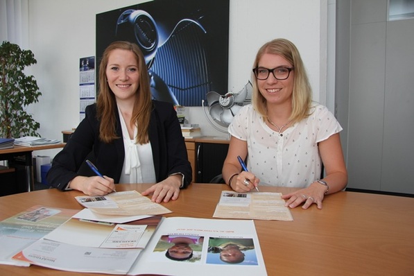 Jennifer Zürn (links) und Marlen Geißler unterzeichnen für die Ziehl-Abegg-Auszubildenden die Patenschaftsübernahme für zwei Kinder in Swasiland.