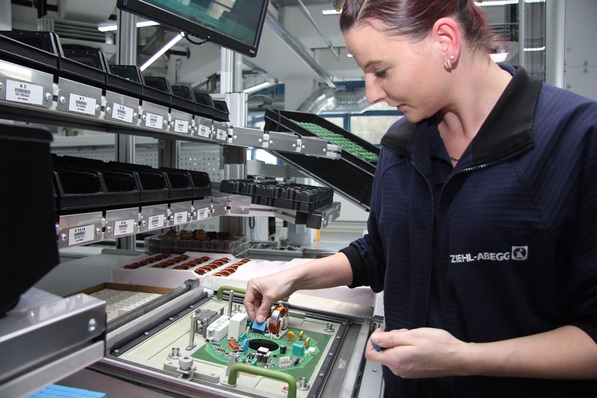Ziehl-Abegg hat bei der manuellen Bestückung der Leiterplatten für die Elektromotoren ein neues System eingeführt, das die Fehlerquote auf null Prozent senkt. Gabriela Szworc setzt Elemente, die maschinell nicht montiert werden können, von Hand auf die Leiterplatten, die später in Elektromotoren verbaut werden.