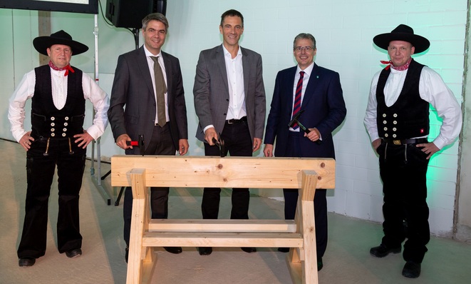Symbolisch schlugen die drei Vaillant Group-Geschäftsführer Dr. Andree Groos (2. v. l.), Dr.-Ing. Norbert Schiedeck (Mitte) und Dr. Stefan Borchers (2. v. r.) den letzten Nagel in einen Dachbalken des neuen Forschungs- und Entwicklungszentrums.